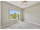 Cozy bedroom with plush carpeting, ceiling fan, and a large window showcasing lush green outdoor views at 16 W Encanto Blvd # 22, Phoenix, AZ 85003