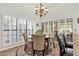 Dining room featuring a round wood table, upholstered chairs, chandelier and plantation shutters for a bright aesthetic at 1978 E Carver Rd, Tempe, AZ 85284