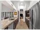 Galley style kitchen featuring stainless steel appliances, granite counters and a view to the living room through an arched doorway at 1978 E Carver Rd, Tempe, AZ 85284