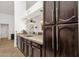 Kitchen area showcasing granite countertops, wood cabinetry, stainless dishwasher and sink, with a view of the front door at 1978 E Carver Rd, Tempe, AZ 85284