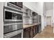 Kitchen featuring stainless steel microwave, oven and refrigerator, granite counters, subway tile backsplash, and wooden cabinets at 1978 E Carver Rd, Tempe, AZ 85284