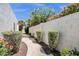 A charming walkway lined with lush landscaping, flowers, and a solid privacy wall at 1978 E Carver Rd, Tempe, AZ 85284