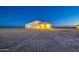 Rear view of a single-story home highlighting a covered patio area and desert landscaping under the night sky at 3033 N 367Th Ave, Tonopah, AZ 85354