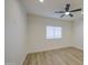 Bright bedroom featuring wood-look tile flooring, ceiling fan, and large window at 3033 N 367Th Ave, Tonopah, AZ 85354