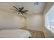 Bright bedroom features wood-look flooring, a modern ceiling fan, and a sunny window at 3033 N 367Th Ave, Tonopah, AZ 85354