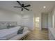 Bedroom with a ceiling fan, light wood-look flooring, and a view of an en-suite bathroom at 3033 N 367Th Ave, Tonopah, AZ 85354