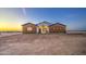 Charming single-story home featuring a combination of white and brown paneling under a twilight sky at 3033 N 367Th Ave, Tonopah, AZ 85354