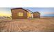 Charming single-story home featuring a combination of white and brown paneling under a twilight sky at 3033 N 367Th Ave, Tonopah, AZ 85354