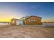 The exterior is a modern home with brown accents and an inviting entrance, set against a scenic sunset at 3033 N 367Th Ave, Tonopah, AZ 85354