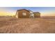 A home exterior showcases modern design elements and is complemented by a landscape and evening sky at 3033 N 367Th Ave, Tonopah, AZ 85354