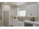 Elegant kitchen with stainless steel sink, marble countertops and backsplash, and modern cabinets at 3033 N 367Th Ave, Tonopah, AZ 85354