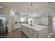 Open kitchen with a central island, white cabinetry, and modern pendant lighting at 3033 N 367Th Ave, Tonopah, AZ 85354