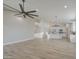 Open-concept living area with sleek wood-look flooring, a modern ceiling fan, and an integrated kitchen at 3033 N 367Th Ave, Tonopah, AZ 85354