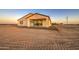 A cozy backyard features a covered patio with a sliding glass door and a small area of rock landscaping at 3033 N 367Th Ave, Tonopah, AZ 85354