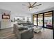 Open-concept living room featuring a large sectional, and sliding glass doors to the outdoor patio and pool at 3713 W Abrams Dr, New River, AZ 85087
