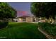 Expansive backyard with lush green lawn, fruit trees, a refreshing pool, and covered patio at 3931 E Fox Cir, Mesa, AZ 85205