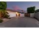 Single-story home with a three-car garage, large driveway, and wooden gates, offering privacy at 3931 E Fox Cir, Mesa, AZ 85205