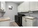 Modern laundry room with matching appliances, sink, and ample white cabinets for storage at 3931 E Fox Cir, Mesa, AZ 85205