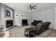 Cozy living room with a fireplace, ceiling fan, and comfortable leather seating at 3931 E Fox Cir, Mesa, AZ 85205
