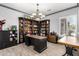 Well-appointed home office with a large desk, built-in shelving, and a chandelier at 3931 E Fox Cir, Mesa, AZ 85205