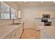 Updated kitchen with white cabinets, stainless steel appliances, and quartz countertops near a sunlit window at 4119 E Tether Trl, Phoenix, AZ 85050