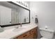 This bathroom offers natural wood cabinets, white walls and countertop, and an elegant, framed mirror at 4631 N 77Th Dr, Phoenix, AZ 85033