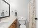 This bathroom offers a floral shower curtain, a white toilet, and a framed mirror above the sink at 4631 N 77Th Dr, Phoenix, AZ 85033