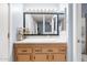 This bathroom features a white countertop, natural wood cabinets, and an eye-catching framed mirror with lights at 4631 N 77Th Dr, Phoenix, AZ 85033