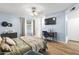 This bedroom features hardwood floors, a TV, a desk, and muted blue walls, creating a calm space at 4631 N 77Th Dr, Phoenix, AZ 85033
