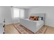 Bright bedroom featuring a bed with a white comforter, wood floors, and neutral walls at 5315 S River Dr, Tempe, AZ 85283