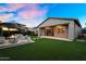 Beautiful backyard featuring artificial grass, a cozy seating area with fire pit, and a covered patio at 10741 E Palladium Dr, Mesa, AZ 85212
