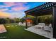 Inviting backyard with a pergola covered patio, fire pit, garden with lush shrubs, and artificial turf at 10741 E Palladium Dr, Mesa, AZ 85212