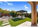 Beautiful backyard with pergola-covered seating area and lush landscaping at 10741 E Palladium Dr, Mesa, AZ 85212