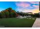 Well-maintained backyard with lush artificial grass, outdoor seating, and a charming pergola, perfect for entertaining at 10741 E Palladium Dr, Mesa, AZ 85212
