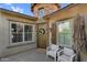 Welcoming home entrance with stone accents, a decorative wreath, and an inviting outdoor seating area at 10741 E Palladium Dr, Mesa, AZ 85212
