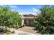 Charming single-story home with lush landscaping and a brick driveway at 10741 E Palladium Dr, Mesa, AZ 85212