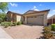 Charming single-story home with stone detailing, a two-car garage, and a neatly paved driveway at 10741 E Palladium Dr, Mesa, AZ 85212