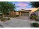 Attractive single-story home with a stone facade, a two-car garage, and a lush, green front yard at 10741 E Palladium Dr, Mesa, AZ 85212