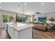 Open-concept kitchen with a quartz countertop island, gold pendant lighting, and seamless flow to the living area at 10741 E Palladium Dr, Mesa, AZ 85212