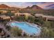 Desert community aerial showcases a pool, dwellings, mountain views, and colorful sky, capturing the essence of tranquil living at 13450 E Via Linda -- # 2041, Scottsdale, AZ 85259