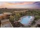 Aerial view featuring the community pool surrounded by residential buildings in a desert landscape under a colorful sky at 13450 E Via Linda -- # 2041, Scottsdale, AZ 85259