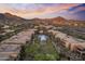 Scenic desert community aerial view featuring a central pool area amid multi-unit dwellings with mountain backdrop, and colorful sky at 13450 E Via Linda -- # 2041, Scottsdale, AZ 85259