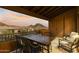 Covered outdoor balcony with a dining table, chairs, and stunning mountain views at sunset at 13450 E Via Linda -- # 2041, Scottsdale, AZ 85259
