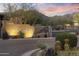 Elegant community entrance featuring desert landscaping, stone accents, and well-lit signage at sunset at 13450 E Via Linda -- # 2041, Scottsdale, AZ 85259