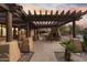Relaxing community patio featuring an outdoor grill, a stone fireplace, and comfortable seating under a wooden pergola at 13450 E Via Linda -- # 2041, Scottsdale, AZ 85259