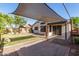 Spacious backyard with a shaded patio, grass, and landscaping at 15814 W Adams St, Goodyear, AZ 85338