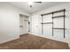 Clean bedroom featuring carpet, closet space, and floating shelves at 15814 W Adams St, Goodyear, AZ 85338