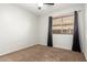 Neutral-toned bedroom with a window, curtains, and plush carpet at 15814 W Adams St, Goodyear, AZ 85338