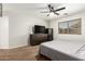 Bright bedroom featuring a ceiling fan, window with blinds and wood dresser and entertainment center at 15814 W Adams St, Goodyear, AZ 85338