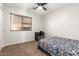 Bright bedroom featuring neutral walls, a window, and a ceiling fan at 15814 W Adams St, Goodyear, AZ 85338